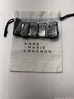 Front view of the Anne Marie Chagnon bracelet displayed on a white cloth branded jewelry bag.