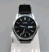 Front view of men's black dial Lorus watch with silver bezel and black leather strap showing day-date window