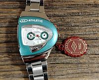 Front view of men's retro sports quartz watch on stainless steel band placed on wood surface, showing dial, subdials, and case details.