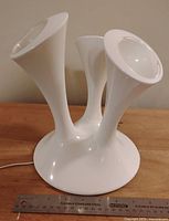 White plastic multi-cone mood light lamp on wood surface with a ruler for size reference