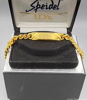 Front view of the gold tone Spiedel men's ID bracelet in original black velvet presentation box, showing the blank ID plate and chain links.