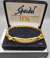 Front view of one gold-toned Spiedel identity bracelet in original velvet box with lid open showing logo inside.