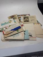 Photo showing a pile of assorted vintage Christmas cards and postcards with varied designs.