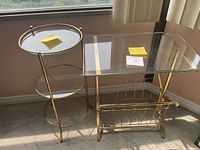 Photo of the round tiered brass and glass side table alongside the rectangular side table with magazine rack under glass top.
