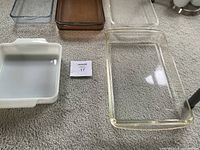 Close-up of rectangular clear glass baking dishes and white ceramic dish with handles.