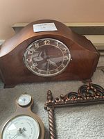 Wide angle shot of the mantel clock, barometer, and one spoon rack showing overall scale and condition
