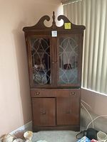 Full front view of the traditional wooden hutch showing glass doors, drawer, and bottom cabinet doors.