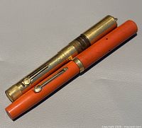 Gold-filled and orange Waterman pens capped