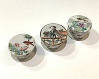 Three lidded ointment jars top view showing hand painted scenes