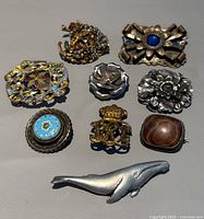 All eight brooches laid out together on flat surface