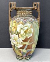Front view showing full vase, floral design, and handles