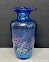 Front view of blue iridescent art glass vase with swirl pattern