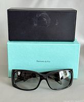 Sunglasses with case atop blue Tiffany box