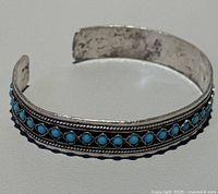 Full view of cuff showing turquoise stones and open design