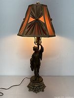 Lamp illuminated showing shade glow and figure detail