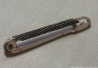 Front view of elongated safety pin brooch showing chain accent