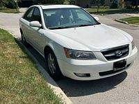 Front right three-quarter view showing white front bumper, grille, headlights, alloy wheel