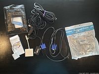 Overview of all cables and adapters in the lot including packaged Ethernet adapter, VGA to HDMI cable, USB charging cables, and adapters