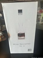 White and slightly dented cardboard box with Casa Elite branding and product text indicating a 750 ml wine decanter. Image shows front with product name and logo.