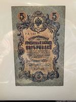 Front side of the 1909 Russia Empire 5 Rubles banknote showing ornamental design, denomination, Russian text, and serial number UA-129.