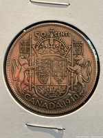 Reverse side of the 1940 Canadian 50 cents half dollar coin displaying the Canadian coat of arms and denomination.