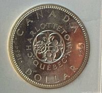 Reverse side showing Charlottetown Quebec commemorative emblem with floral design and inscriptions.