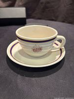 Front view of the Canadian National Railway cup on its matching saucer showing logo and rim details.
