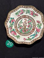 Top view of Coalport bone porcelain trinket dish with scalloped edges, Indian Tree floral design in pink, blue, and green with gold and brown highlights.