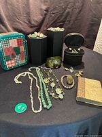 Wide shot of all jewelry items, book and boxes on black table