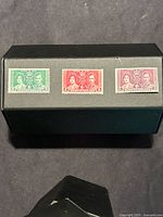Photo showing the set of three Newfoundland 1939 Royal Visit unused stamps in green, red, and purple.