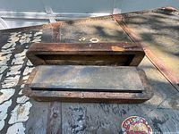 Rectangular sharpening stone inside a fitted wooden box, showing the stone and inner box interior.