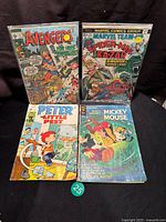 Lot of four vintage comic books displayed together showing front covers with various characters and titles.