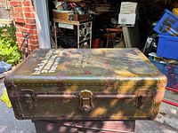 Top exterior view of the military steamer trunk showing olive drab finish and painted name and location.