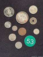 Overview of all 11 coins and tokens on black background next to green lot marker 53