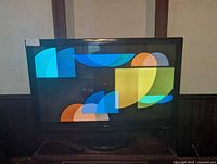 Front view of the 50-inch LG LED TV displaying abstract colorful shapes, showing the TV is on and screen functioning.
