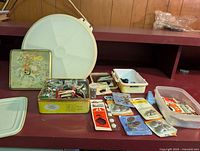 Photo of assorted snap and button makers, fabric squares, and sewing notions in various containers.