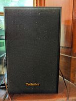Technics black speaker with front grille and gold logo