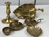 Group photo of three candlesticks, leaf dish, and two small bowls arranged together on white surface.