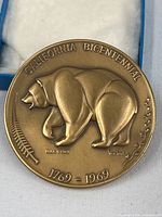 Obverse side of bronze California Bicentennial medal showing bear, dates, and artist signature.