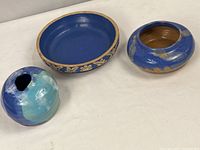 Clay City pottery 8.5 inch pie plate with blue interior and floral carved rim alongside two hand-formed stoneware vases in blue and aqua.