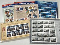 Five sets of collectible U.S. postage stamps in original sealed plastic sleeves, including 'Celebrate the Century' 1900s and 1910s sheets, and others depicting historic events and marine life.