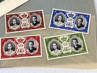 Close-up of four Monaco royal wedding commemorative stamps from 1956, showing portraits of Prince Rainier and Princess Grace with different denominations and colors.