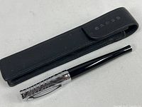 Full view of Cross pen alongside black leather pouch with magnetic flap and Cross embossing.