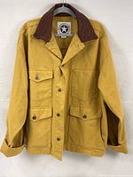 Front view of an XXL mustard/tan unlined jacket with dark brown leather collar, buttoned multiple pockets, and button front.