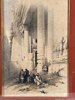 Close-up of the print showing tribal people near large classical columns and stone statues at ruins.