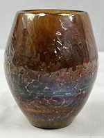 Front angled view showing the mottled amber and brown colors with iridescent sheen and a textured surface.