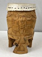 Front view of the hand carved Mexican drum showcasing carved face and floral designs.