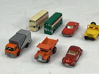 All seven toy vehicles arranged on a gray surface showing overall lot content.