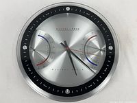 Full view of the round Modern Tech Weather Watch wall clock showing time, humidity, and temperature dials.