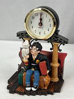 Front view of the Harry Potter desk clock showing Harry holding Hedwig with luggage and clock above.